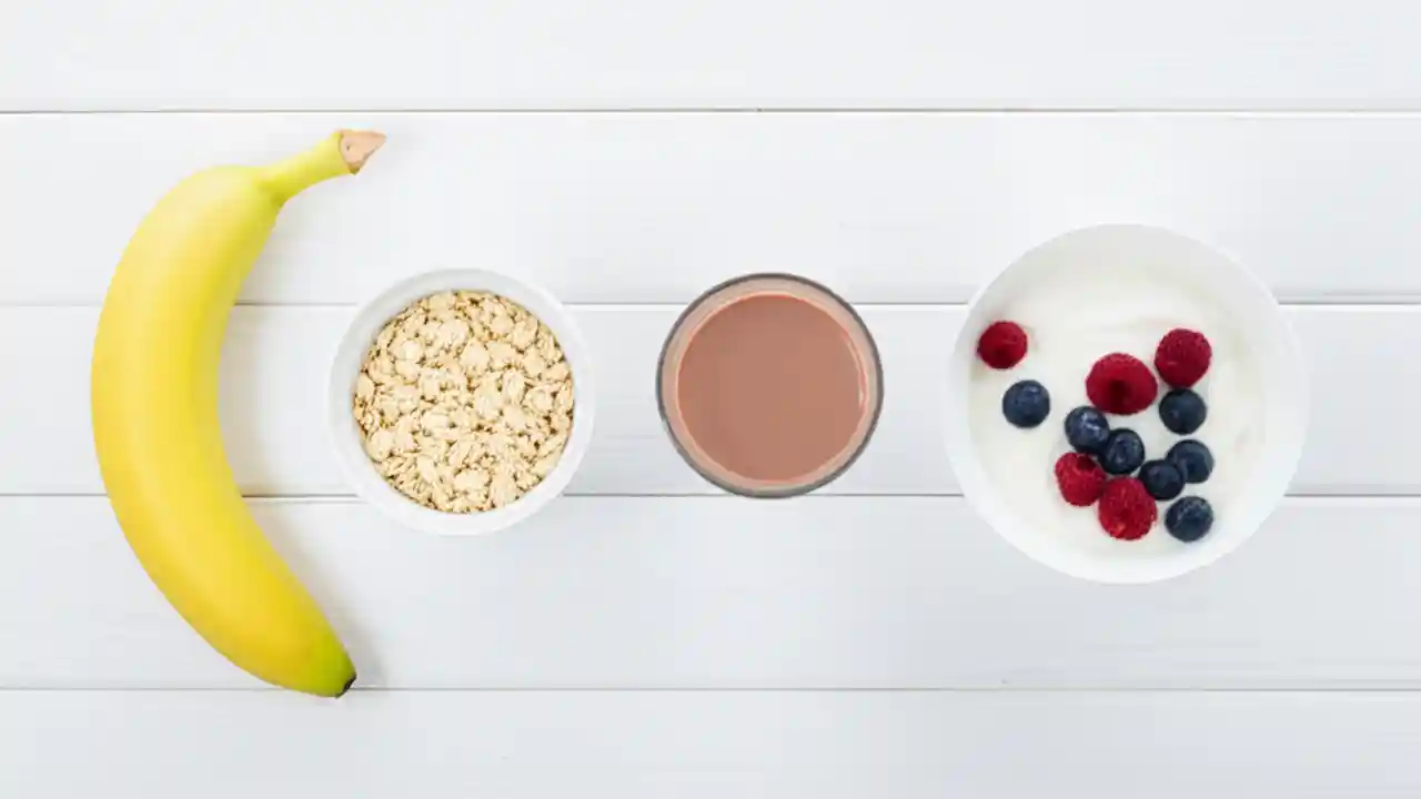 A flat-lay image showing the best pre-workout snacks like a banana and oatmeal, and post-workout snacks like chocolate milk and Greek yogurt.